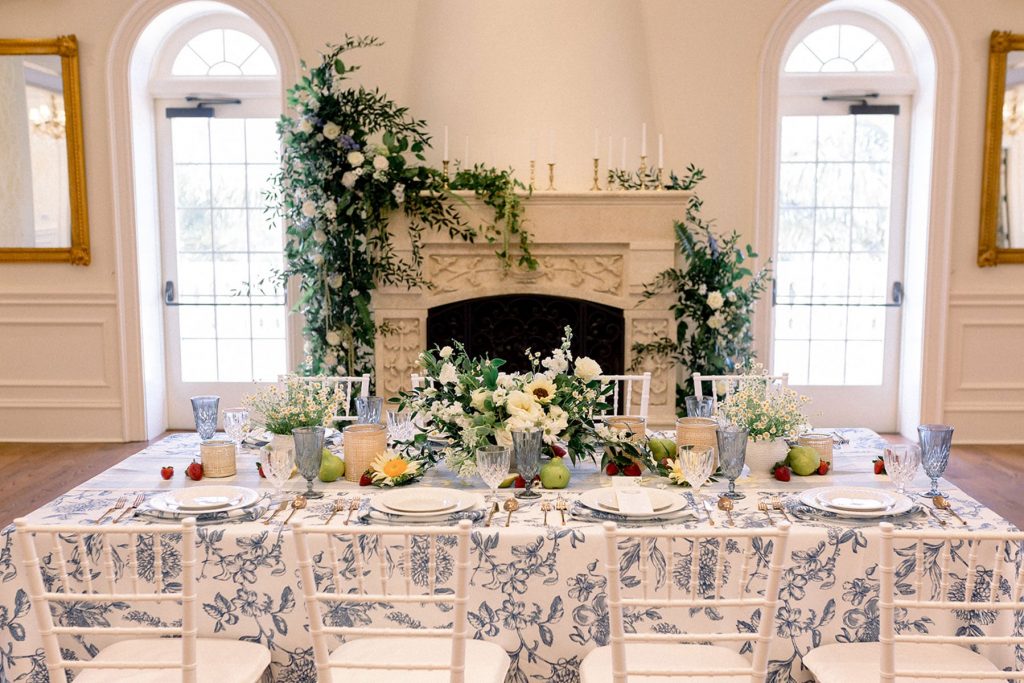 wedding reception table with white and blue linen and greenery